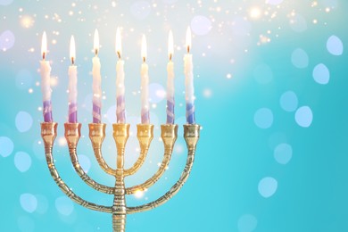 Hanukkah celebration. Menorah with burning candles on light blue background with blurred lights, space for text