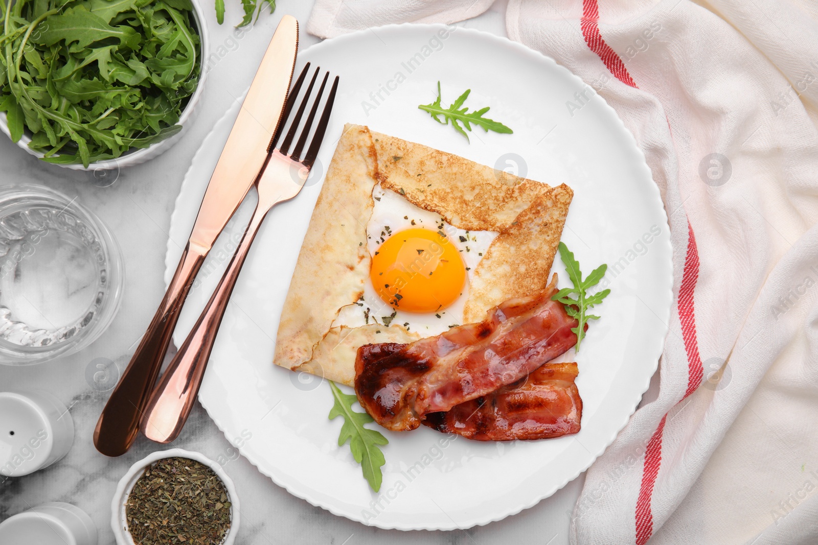 Photo of Delicious crepe with egg served on white marble table, flat lay. Breton galette