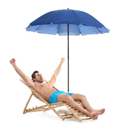 Young man on sun lounger under umbrella against white background. Beach accessories