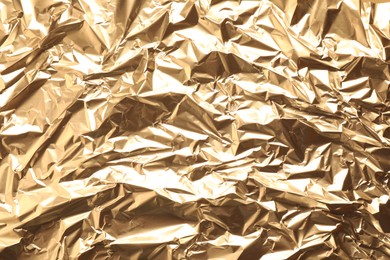 Crumpled gold foil as background, top view