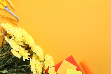 Photo of Beautiful flowers and stationery on orange background, flat lay with space for text. Teacher's Day