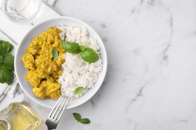 Photo of Delicious rice and chicken with curry sauce on white marble table, flat lay. Space for text