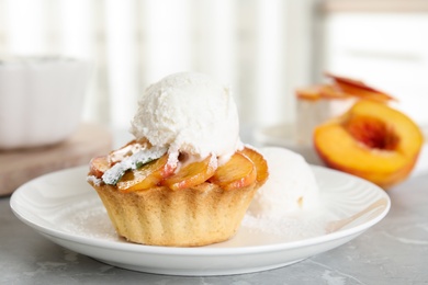 Delicious peach dessert with ice cream on light marble table