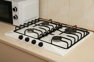 Photo of Modern gas cooktop and microwave oven in kitchen