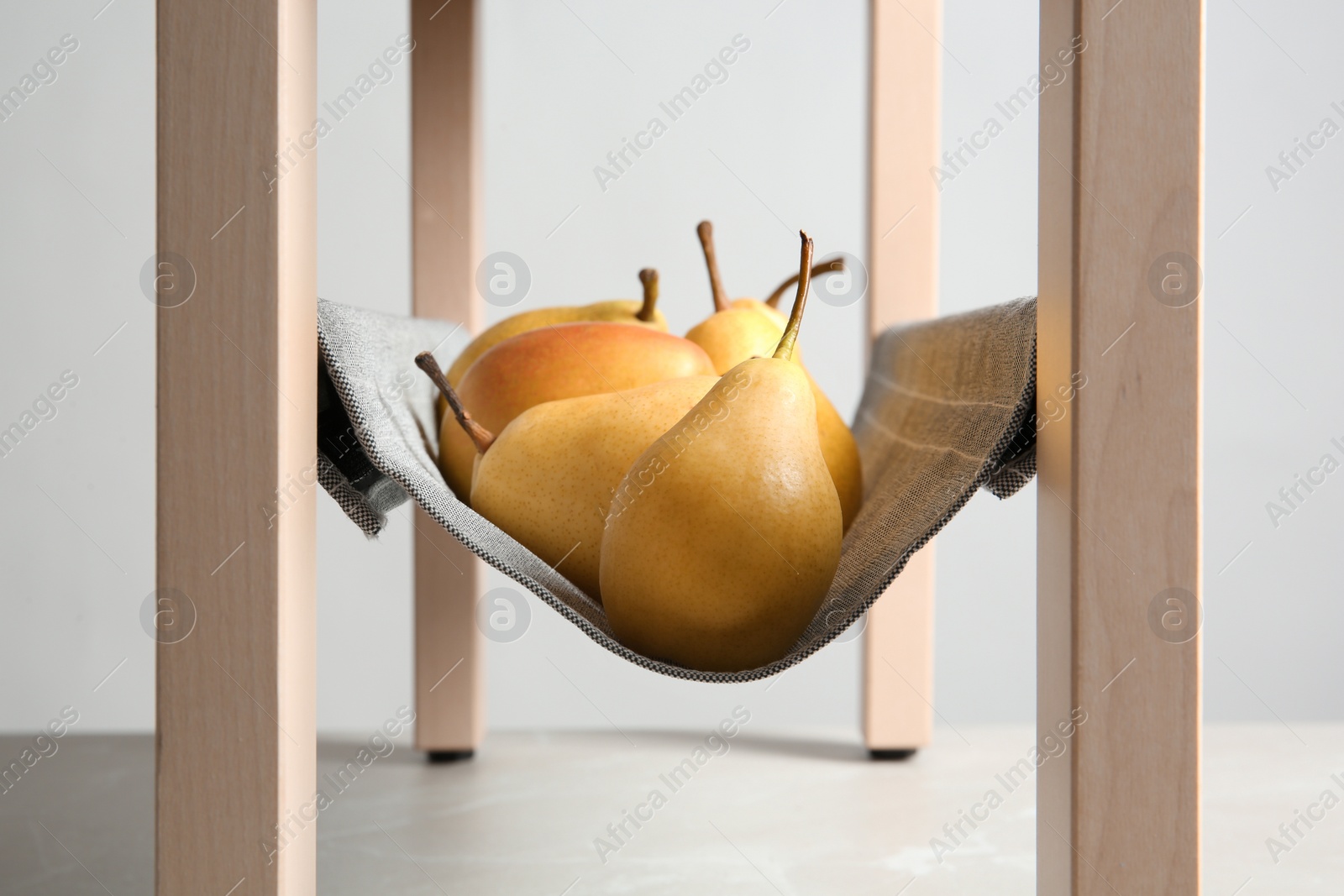 Photo of Ripe yellow pears on fabric shelf indoors