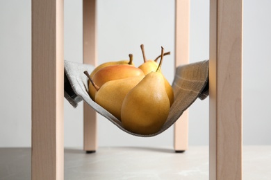 Ripe yellow pears on fabric shelf indoors