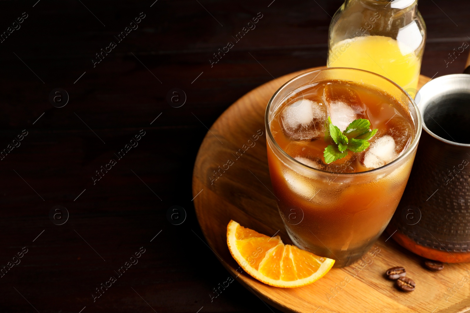 Photo of Tasty refreshing drink with coffee and orange juice on wooden table, closeup. Space for text