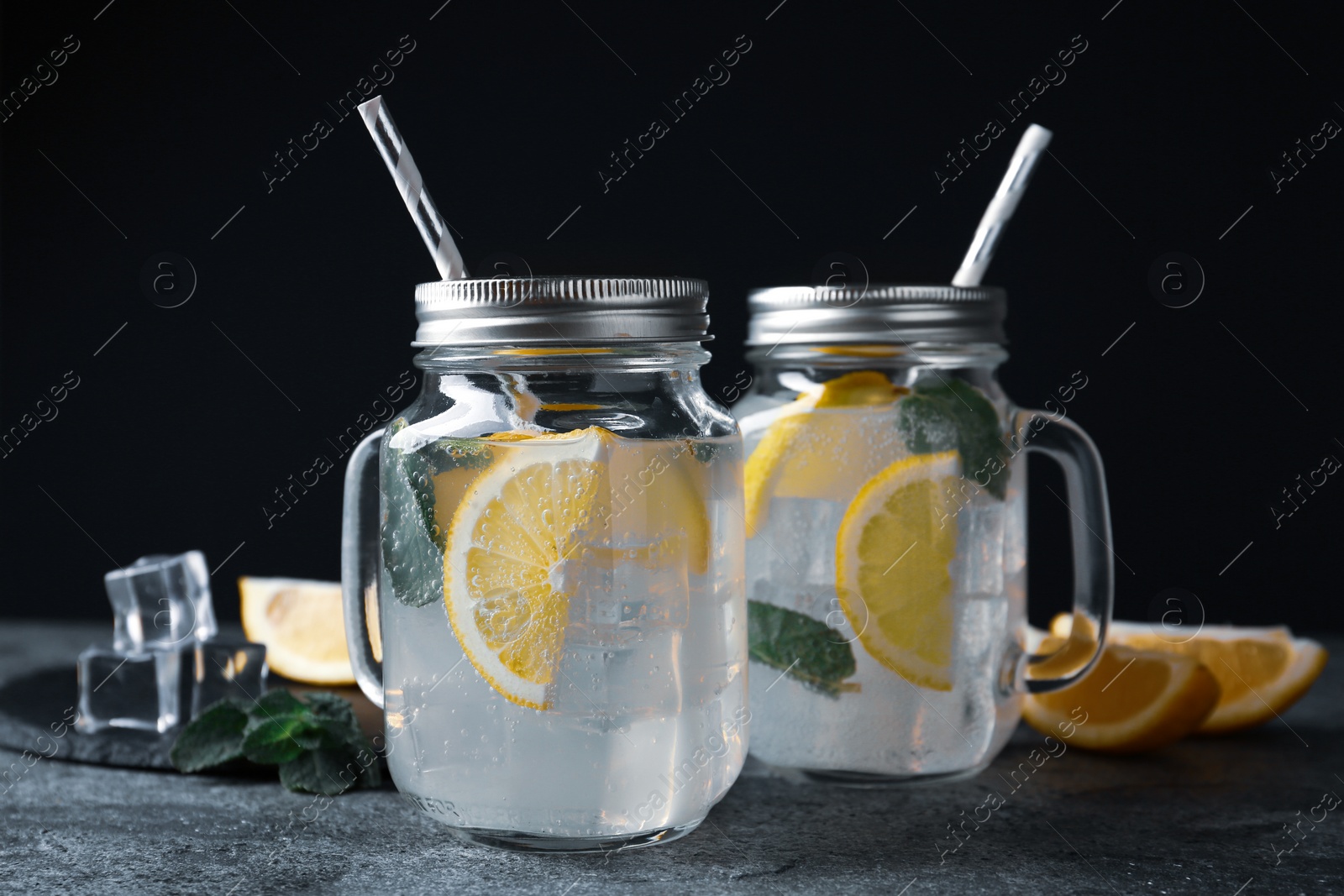 Photo of Delicious lemonade in mason jars on grey table