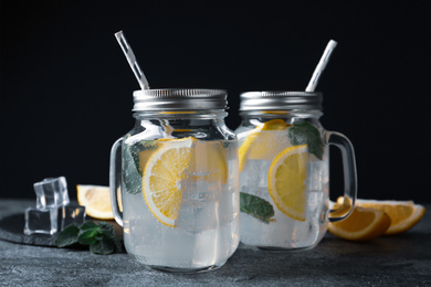 Photo of Delicious lemonade in mason jars on grey table