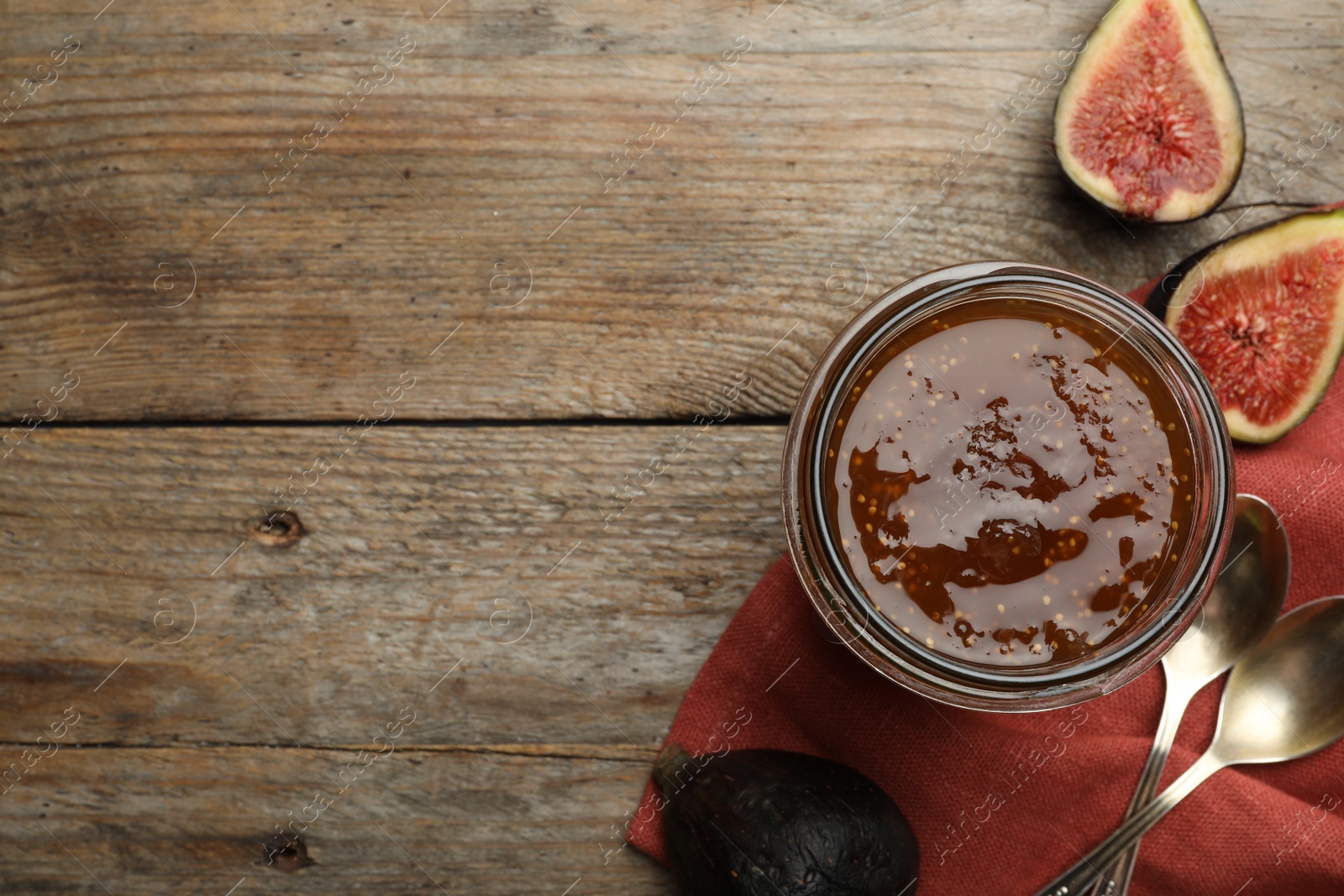 Photo of Homemade delicious fig jam on wooden table, flat lay. Space for text