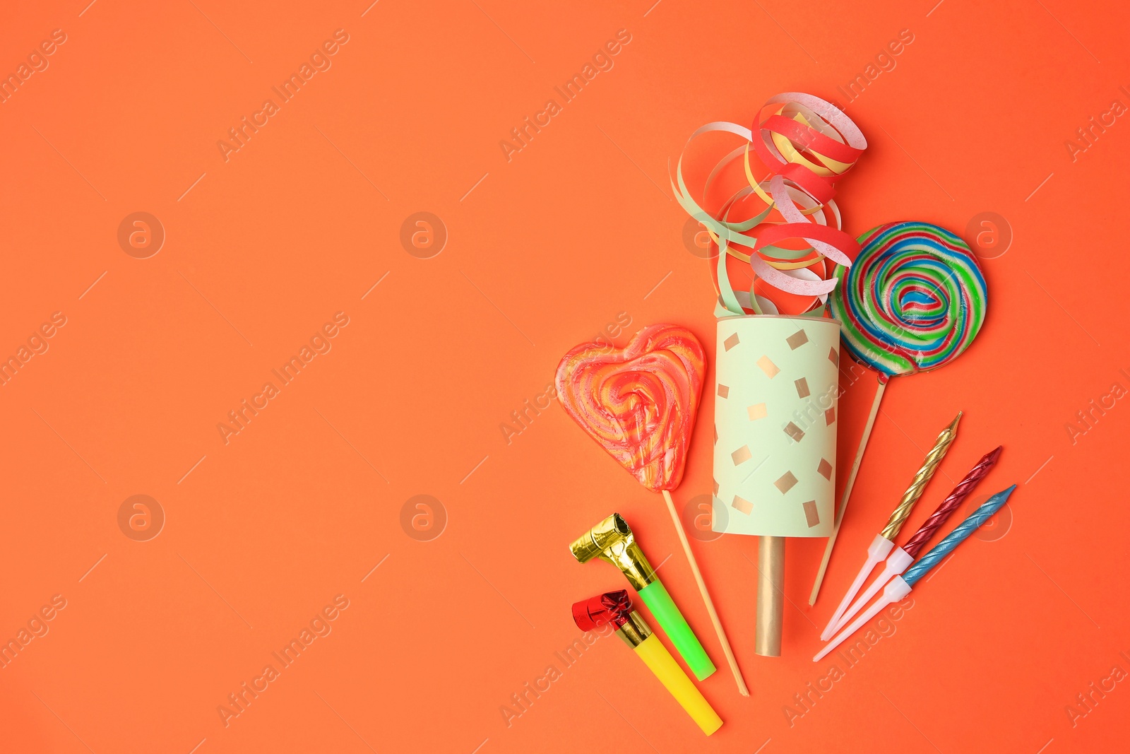 Photo of Party cracker and different festive items on orange background, flat lay. Space for text