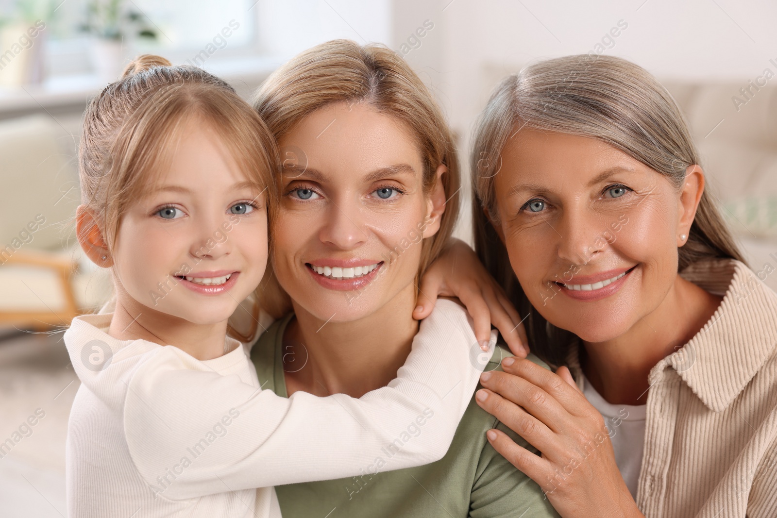 Photo of Three generations. Happy grandmother, her daughter and granddaughter at home