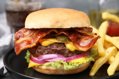 Photo of Tasty burger with bacon, vegetables and patty served with french fries on table, closeup