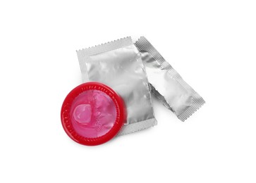 Photo of Unpacked condom and package on white background, top view. Safe sex
