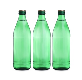 Photo of Glass bottles with water on table against white background