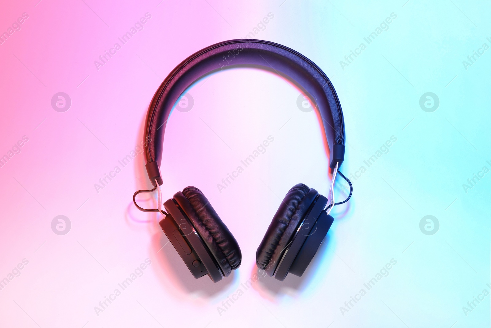 Photo of Stylish headphones on color background, top view