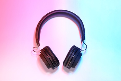 Stylish headphones on color background, top view