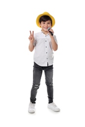 Cute little boy singing into microphone on white background