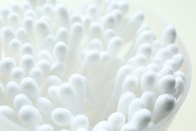 Photo of Many cotton buds in cup on white background, closeup