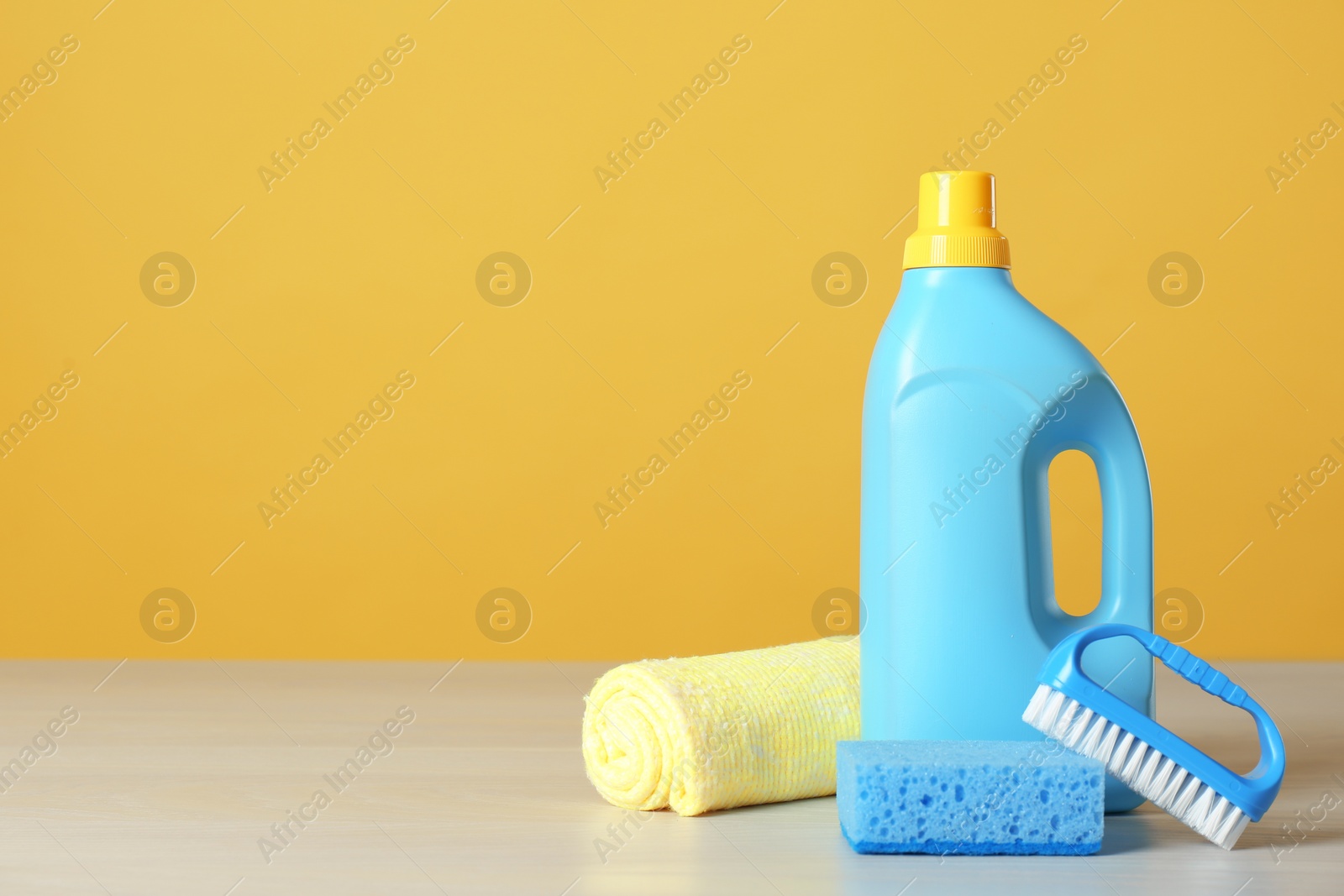 Photo of Bottle of cleaning product and supplies on light table. Space for text