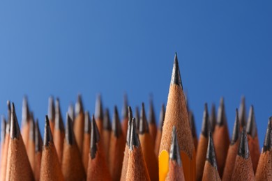 Photo of Sharp graphite pencils on blue background, closeup. Space for text