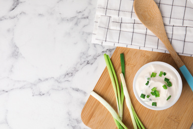 Photo of Fresh sour cream with onion on white marble table, flat lay. Space for text