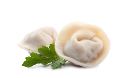 Photo of Boiled dumplings and parsley leaves on white background