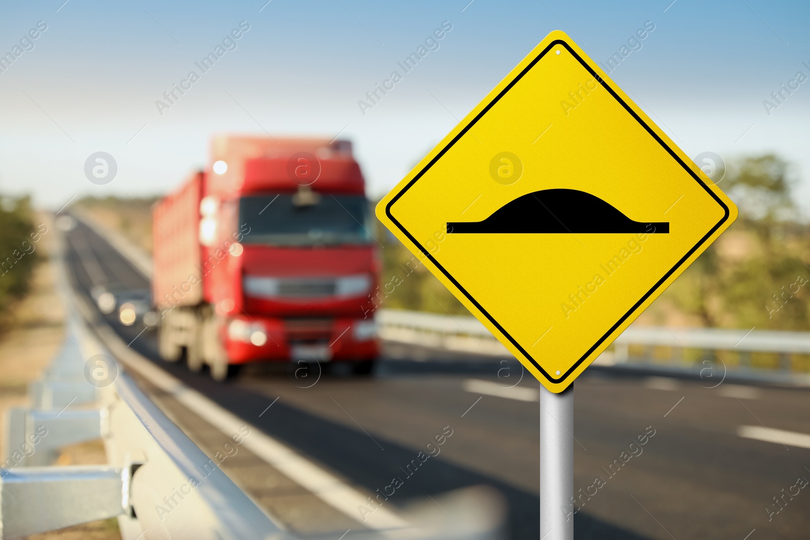 Image of Sign Speed Bump near asphalt road outdoors 