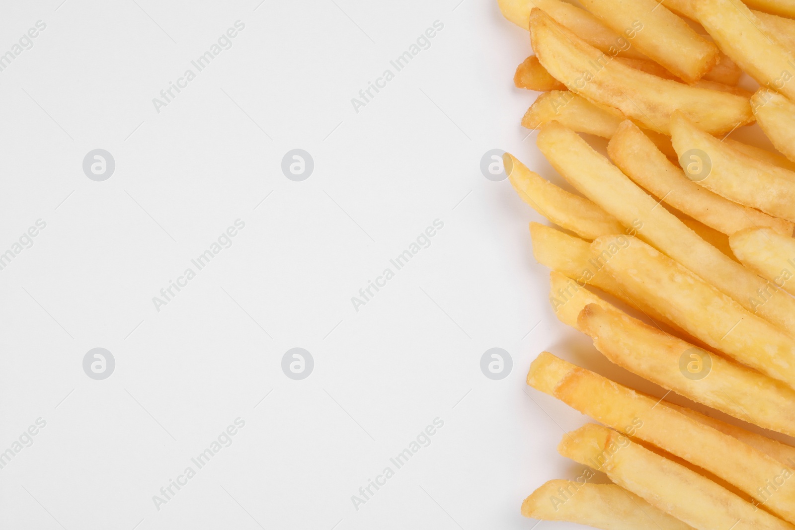 Photo of Delicious french fries on white background, flat lay. Space for text