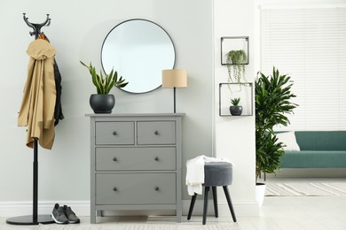 Photo of Hallway interior with stylish furniture, clothes rack and mirror
