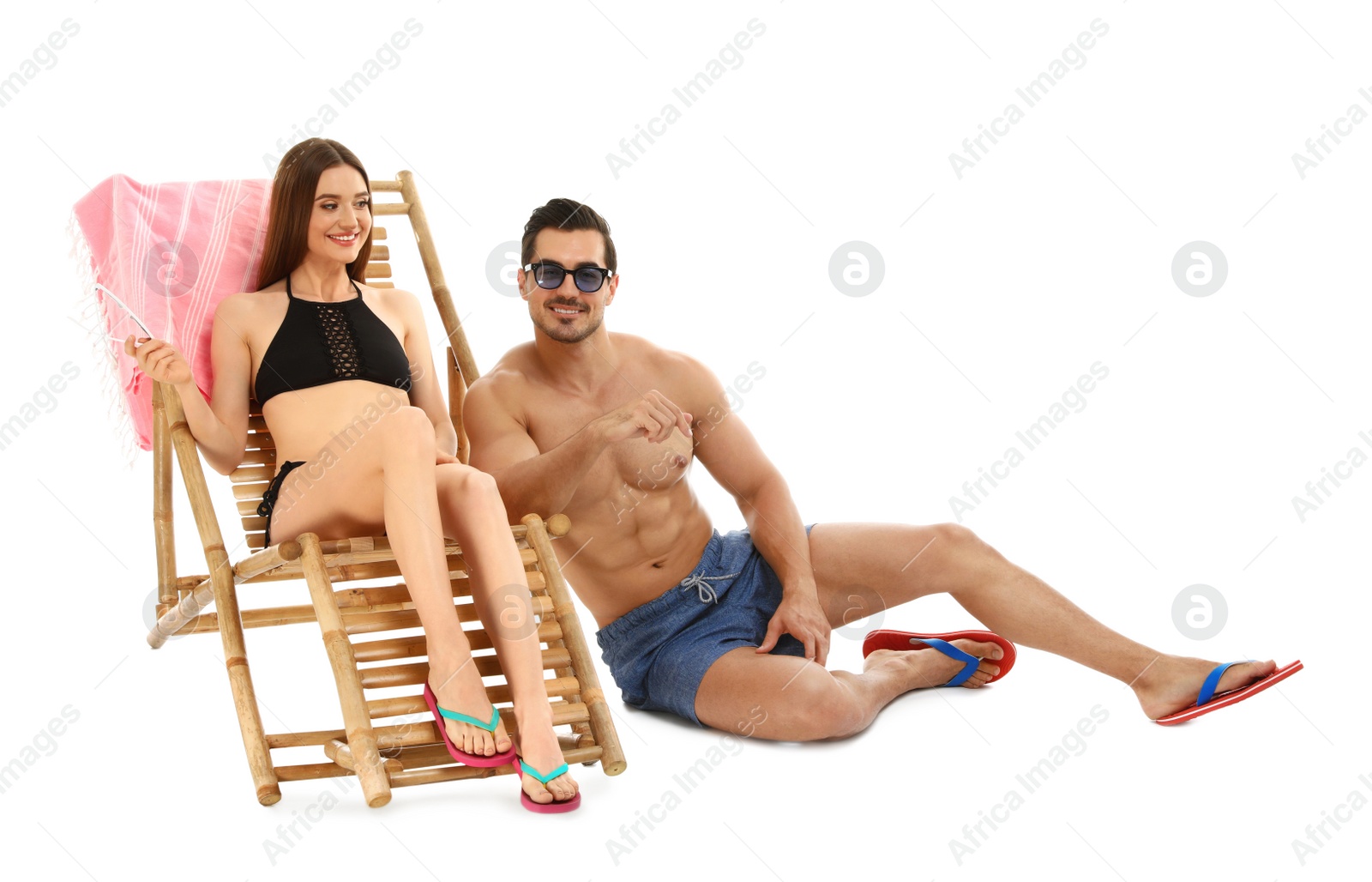 Photo of Young couple with sun lounger on white background. Beach accessories