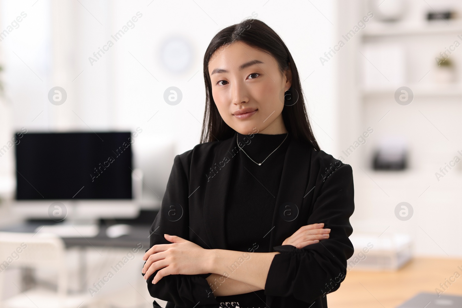 Photo of Portrait of beautiful businesswoman with crossed arms in office