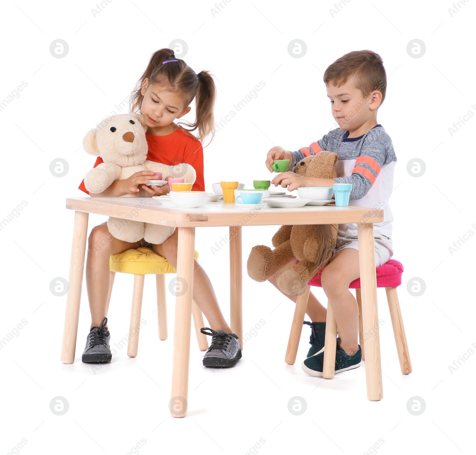 Photo of Little children playing tea party with toys on white background. Indoor entertainment