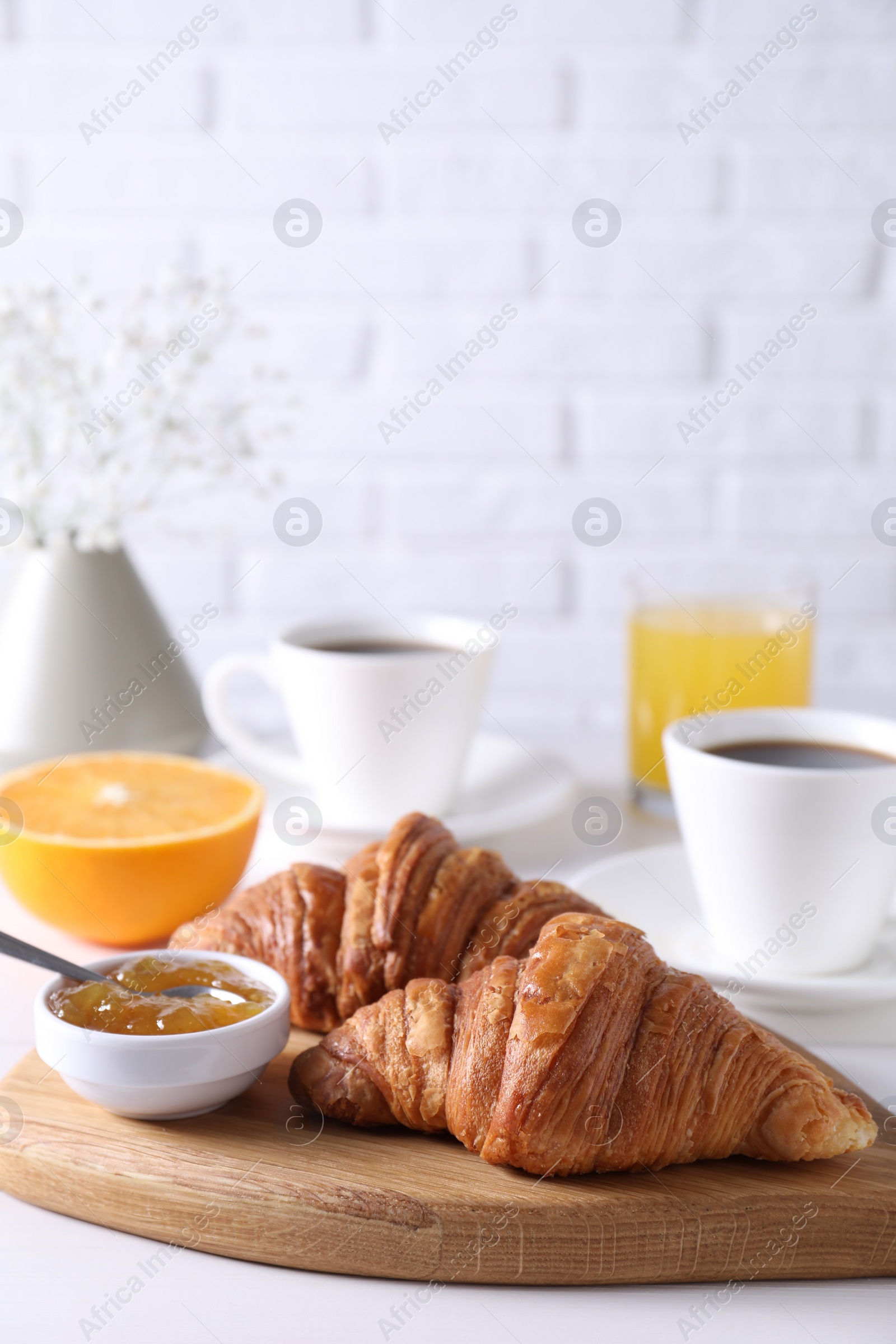 Photo of Croissants and jam on white wooden table. Tasty breakfast