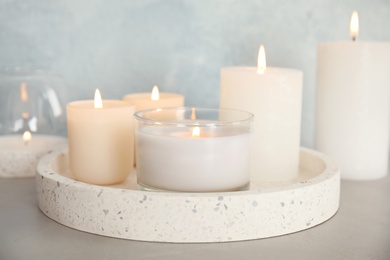 Photo of Tray with burning aromatic candles on table
