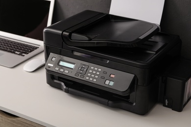 Modern printer on white table, closeup view