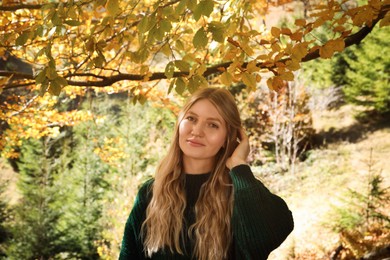 Photo of Portrait of beautiful young woman in autumn forest