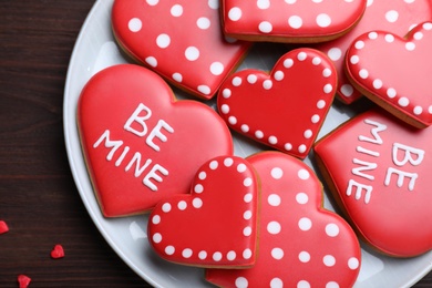 Photo of Decorated heart shaped cookies on wooden table, top view. Valentine's day treat