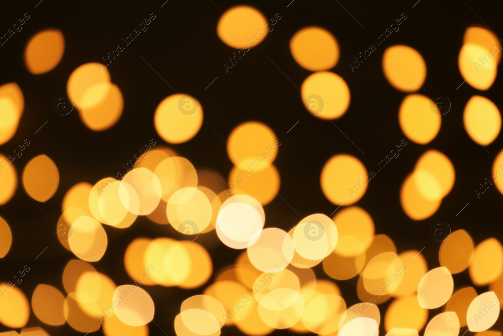 Photo of Beautiful golden lights on dark background. Bokeh effect