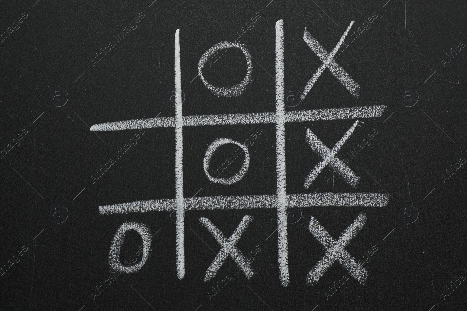 Photo of Tic tac toe game on blackboard, top view