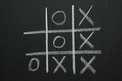 Tic tac toe game on blackboard, top view