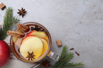 Aromatic hot mulled cider on grey table, flat lay. Space for text