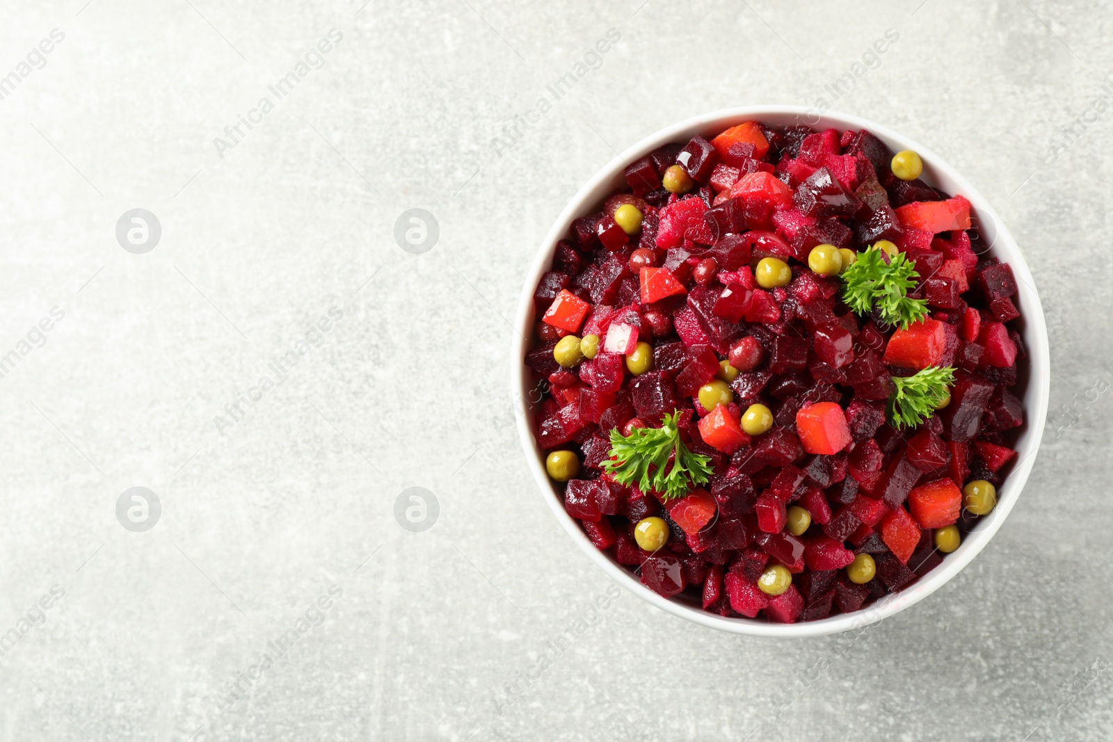 Photo of Traditional Russian vinaigrette salad on light table, top view. Space for text