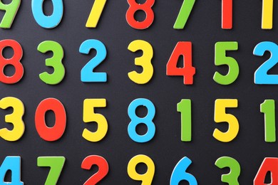 Photo of Colorful numbers on black background, flat lay