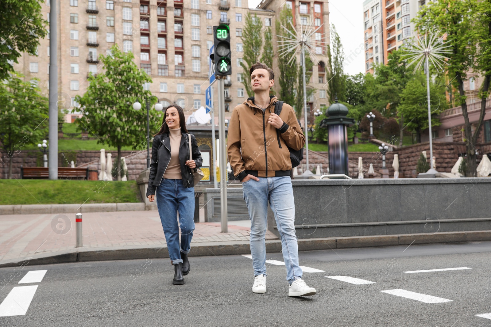 Photo of Young people crossing street at traffic lights