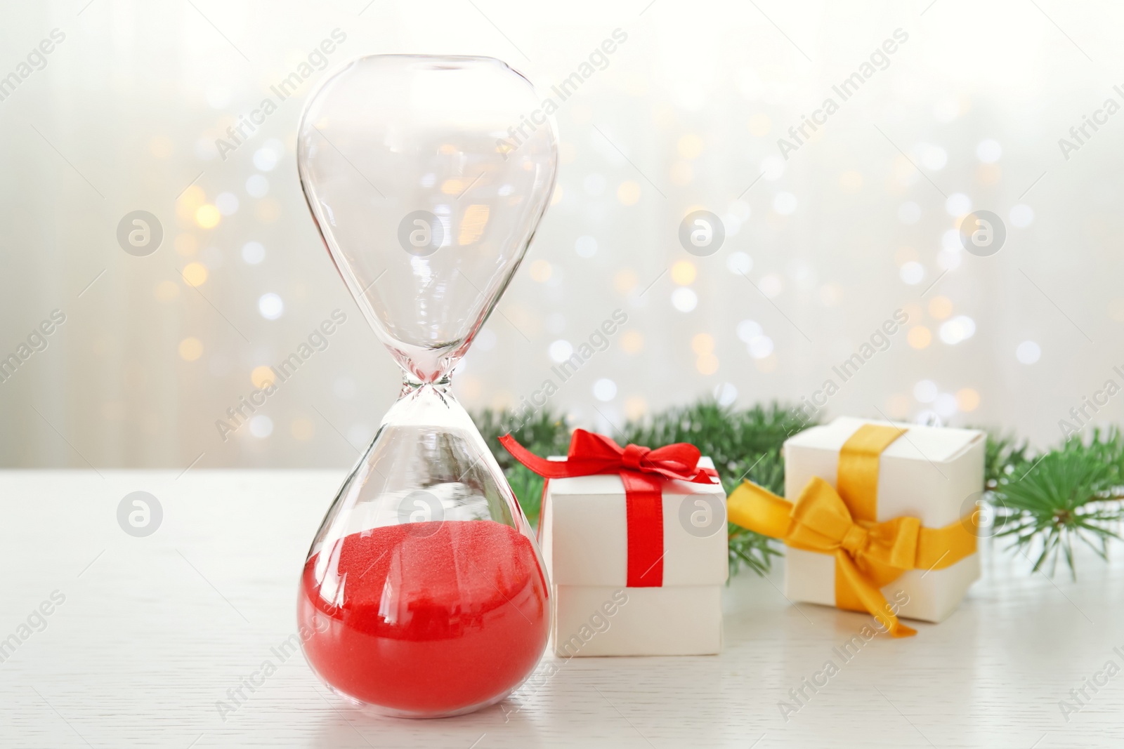 Photo of Hourglass with gifts and decor on table. Christmas countdown