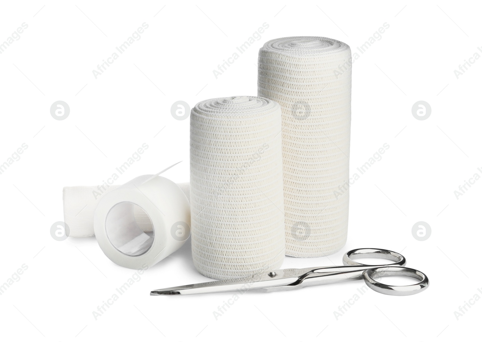 Photo of Medical bandage rolls, sticking plaster and scissors on white background