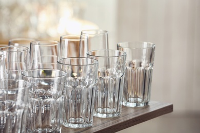 Photo of Empty glasses on wooden table against blurred background