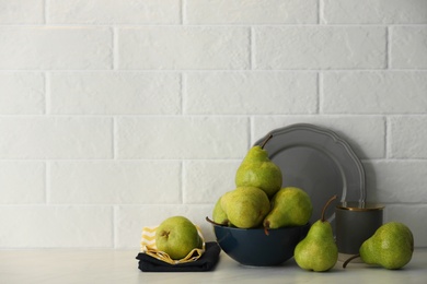 Photo of Fresh ripe pears on white table. Space for text