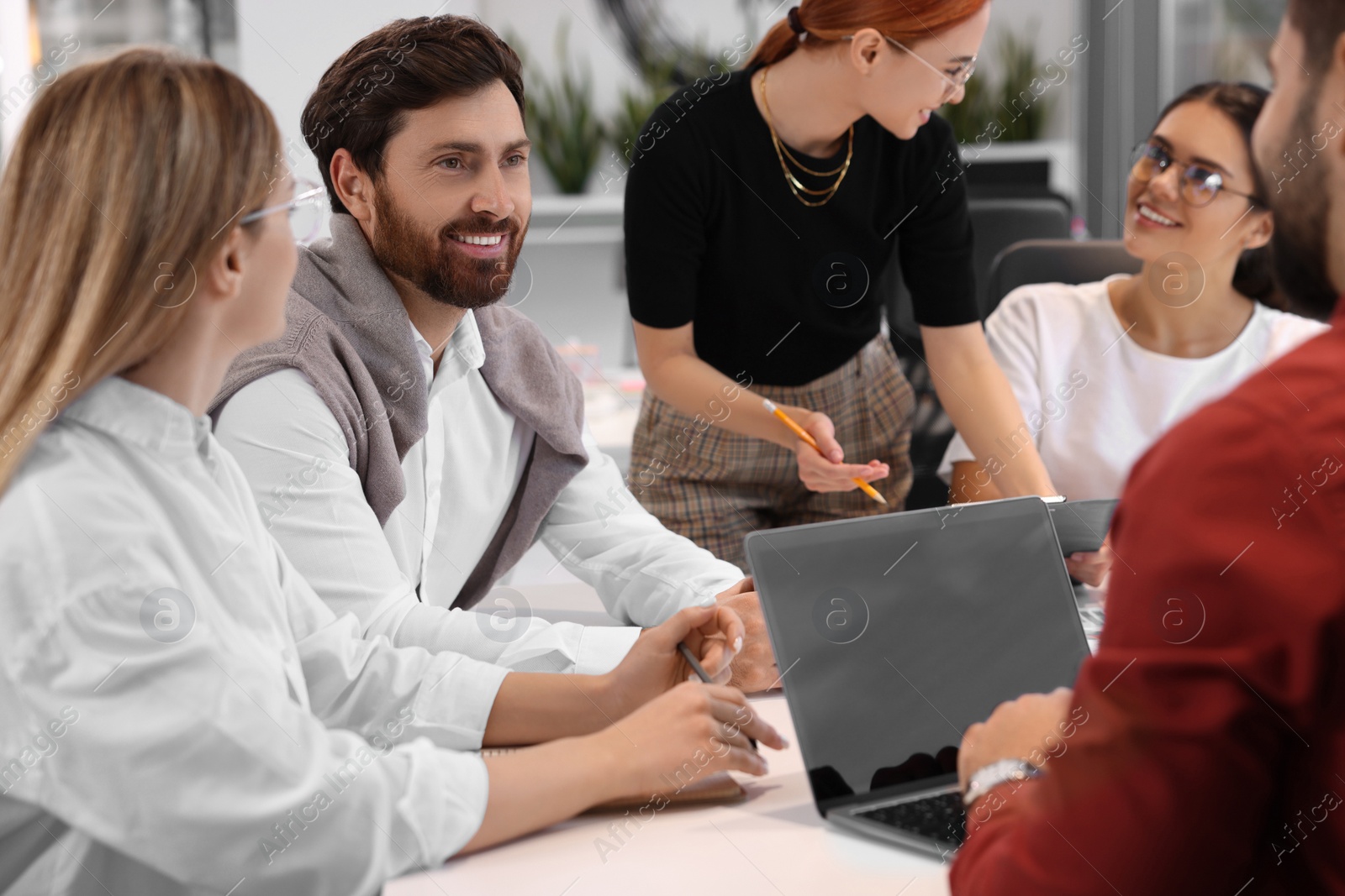 Photo of Team of employees working together in office